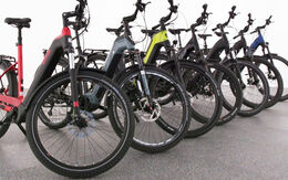 7 Offroad-E-Bikes stehen aufgereiht seitlich im Bild.