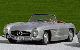 Ein Mercedes Cabriolet steht in einer geschotterten Einfahrt, umgeben von grünem Gras.