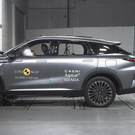 ÖAMTC-Crashtest: Omoda 9 Das Foto zeigt ein graues Auto von der Seite, das gerade im Zuge eines Crashtests frontal gegen ein Hindernis prallt.