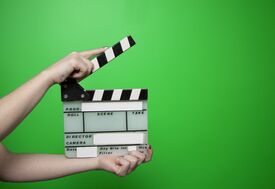 eine Filmklappe vor einem Green Screen