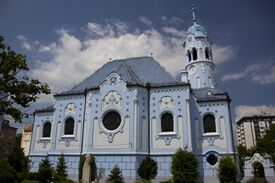 eine blaue Kirche mit einem Turm