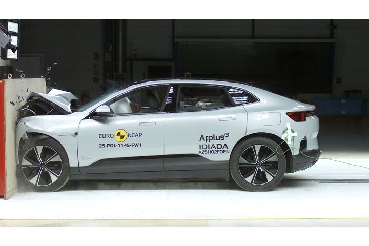 Das Foto zeigt ein hellgraues Auto von der Seite, das gerade im Zuge eines Crashtests frontal gegen ein Hindernis prallt.