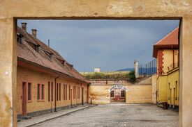 Braunes Backsteingebäude in Theresienstadt mit dem Schriftzug Arbeit macht Frei