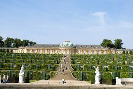 Ein Schloss mit vielen Außentreppen, Gärten und Statuen
