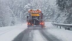 Schneepflug von hinten auf einer schneebedeckten Straße