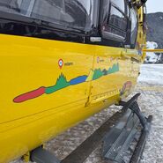 Ein gelber Notarzthubschrauber in winterlicher Landschaft.