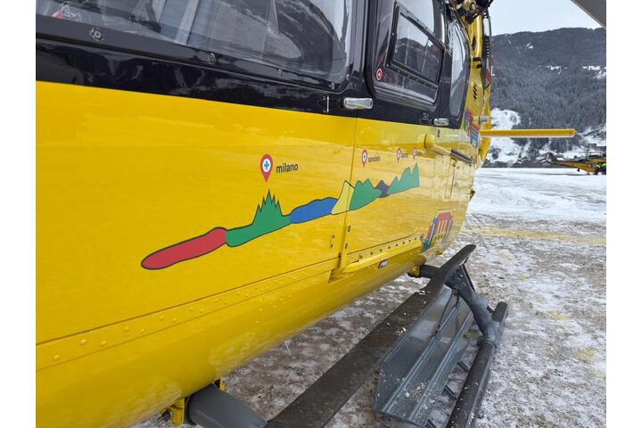 Ein gelber Notarzthubschrauber in winterlicher Landschaft.