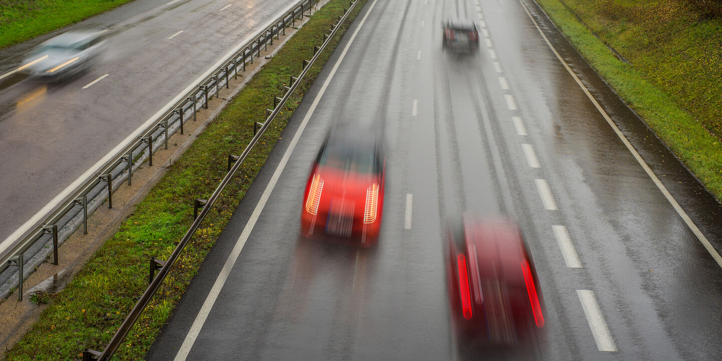 Verschwommenes Bild eines Geisterfahrers in einem roten Auto auf der Autobahn
