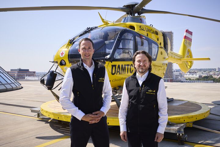 2 Männer vor einem ÖAMTC Hubschrauber