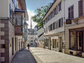 Eine gepflasterte Straße mit alten Häusern in der Zürcher Altstadt