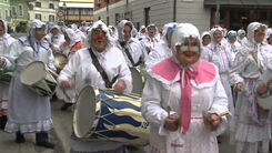 Trommelnde maskierte Personen bei einem Faschingsumzug