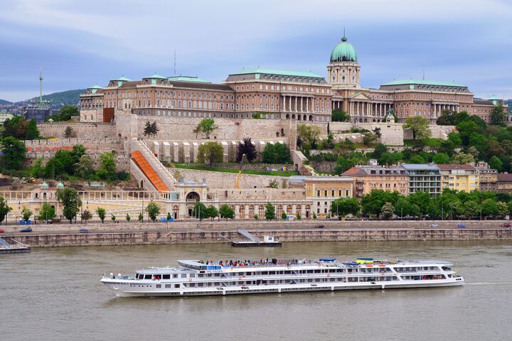 Eine große Burg hinter einem Schiff auf der Donau