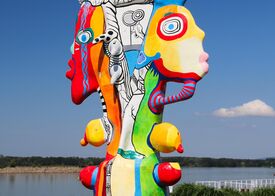 Eine bunte Skulptur auf Steinen direkt am Ufer der Donau