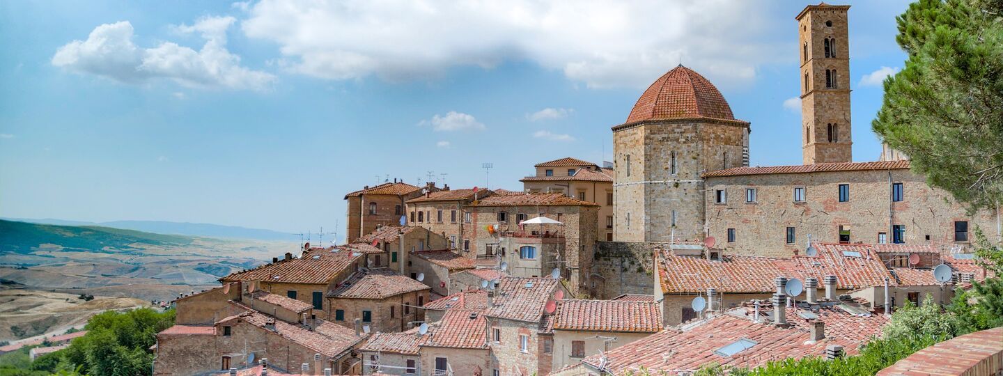Panoramablick auf die mittelalterliche Altstadt von Volterra in der Toskana, umgeben von sanften Hügeln Italiens